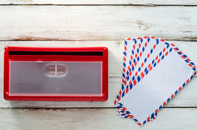 Close-up of mailbox and envelope on wooden wall