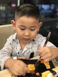 Close-up of boy eating food at home