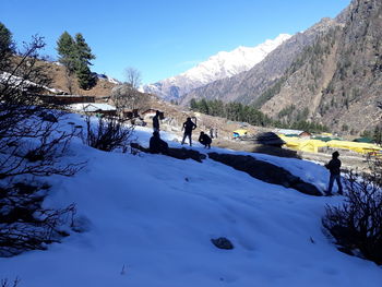 People on snow covered mountain against sky