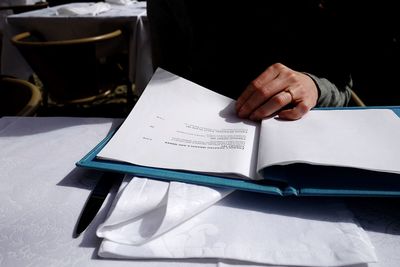 Woman hand on document at table in restaurant