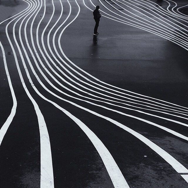 road marking, road, high angle view, transportation, street, shadow, the way forward, pattern, low section, asphalt, unrecognizable person, walking, motion, curve, sunlight, on the move, lifestyles, men