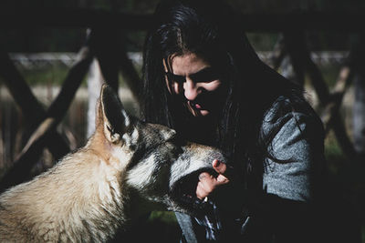 Young woman holding dog outdoors