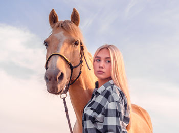 Portrait of beautiful young woman against sky