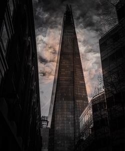 Low angle view of buildings against cloudy sky