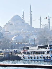 Boats moored in city against buildings