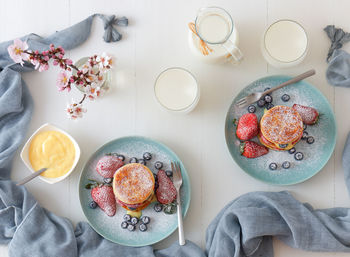Mille feuille, high angle view of french dessert on table with summer berry fruits and lemon curd.