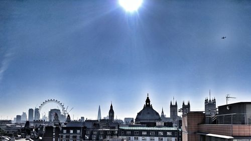 View of buildings in city against blue sky
