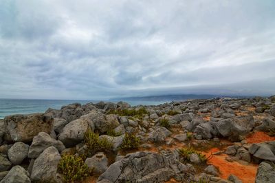 Rocks by sea against sky