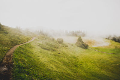 Scenic view of landscape against sky during foggy weather