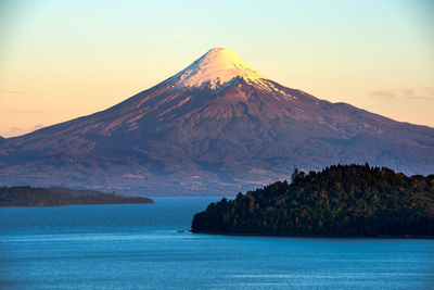 Scenic view of sea and mountain against sky during sunset