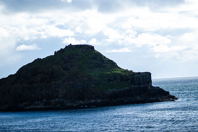 Rock formations by sea against sky