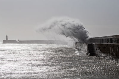 Smoke emitting from sea against sky
