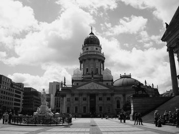 View of buildings in city against cloudy sky