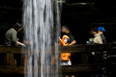 People standing by waterfall