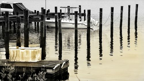Wooden posts in sea against sky
