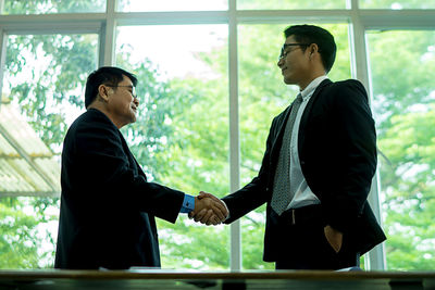 Colleague shaking hands at office