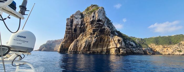 Panoramic shot of rocks in sea against sky