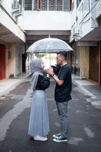 Rear view of woman holding umbrella