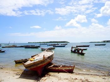 Boats moored on sea against sky