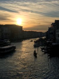 View of buildings at waterfront during sunset