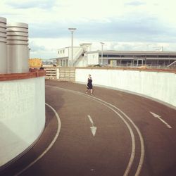 Man walking on road along buildings