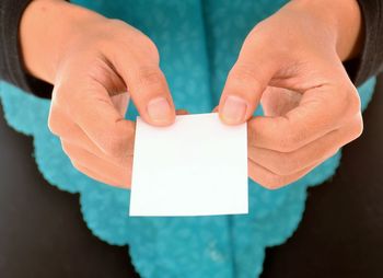 Close-up of man holding paper with text