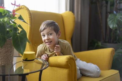 Portrait of young woman sitting on sofa at home