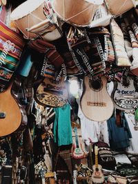 Low angle view of guitars and clothes for sale at market