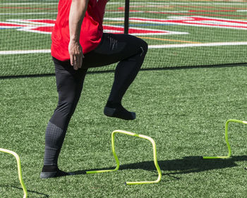 Low section of man standing on soccer field
