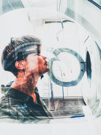 Portrait of man photographing through glass