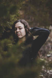 Portrait of young woman by tree