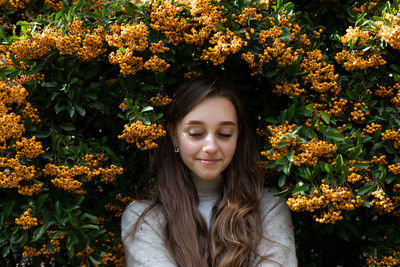 Portrait of a beautiful young woman with red flower