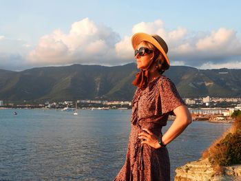 Portrait of woman standing against sea