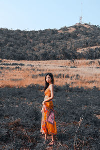 Portrait of woman standing on land against sky