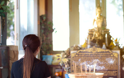 Rear view of woman sitting on table