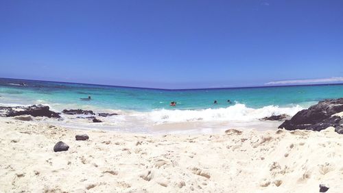 Scenic view of beach against clear blue sky