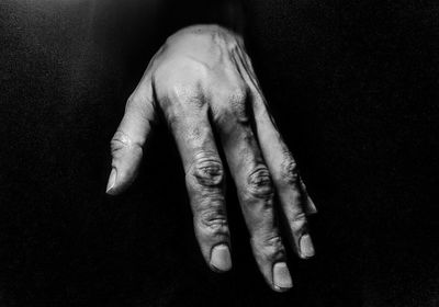 Close-up of woman hands against black background