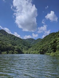 Scenic view of lake by mountains against sky