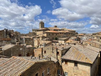 Buildings in town against cloudy sky