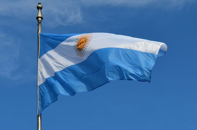 Low angle view of argentinian flag against blue sky