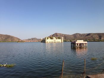 Palace amidst lake against clear sky in city