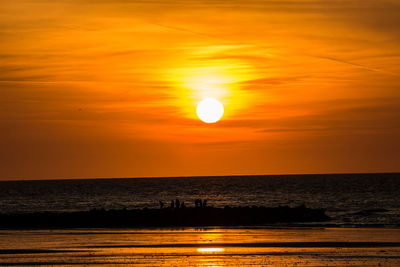 Scenic view of sea against orange sky