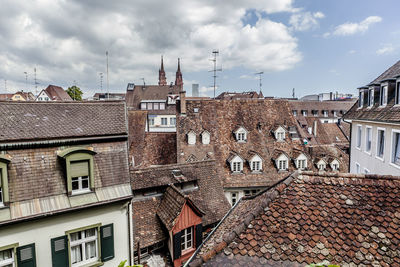 Houses in city against cloudy sky