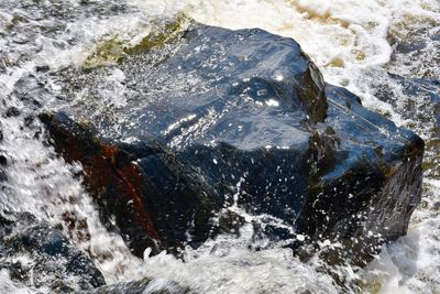 High angle view of sea waves splashing on rocks