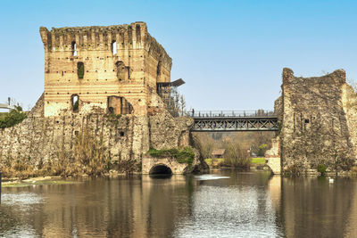 Arch bridge over river against clear sky