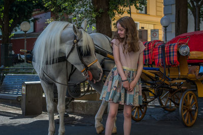 Girl standing against horse outdoors