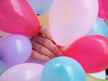 Close-up of hand holding colorful balloons