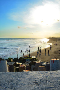 Group of people on beach against sky