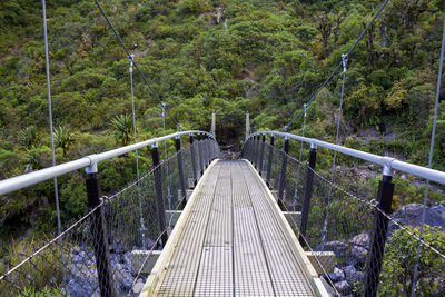 Footbridge amidst trees in forest