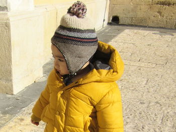 High angle view of cute baby boy in warm clothing standing on street